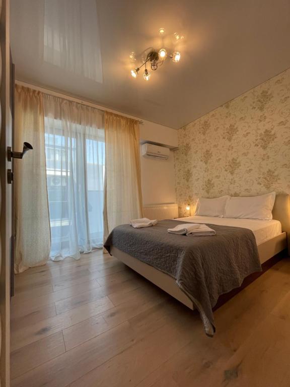 a bedroom with a bed and a large window at Mamaia Beach LuxyMar 3 Apartment in Mamaia