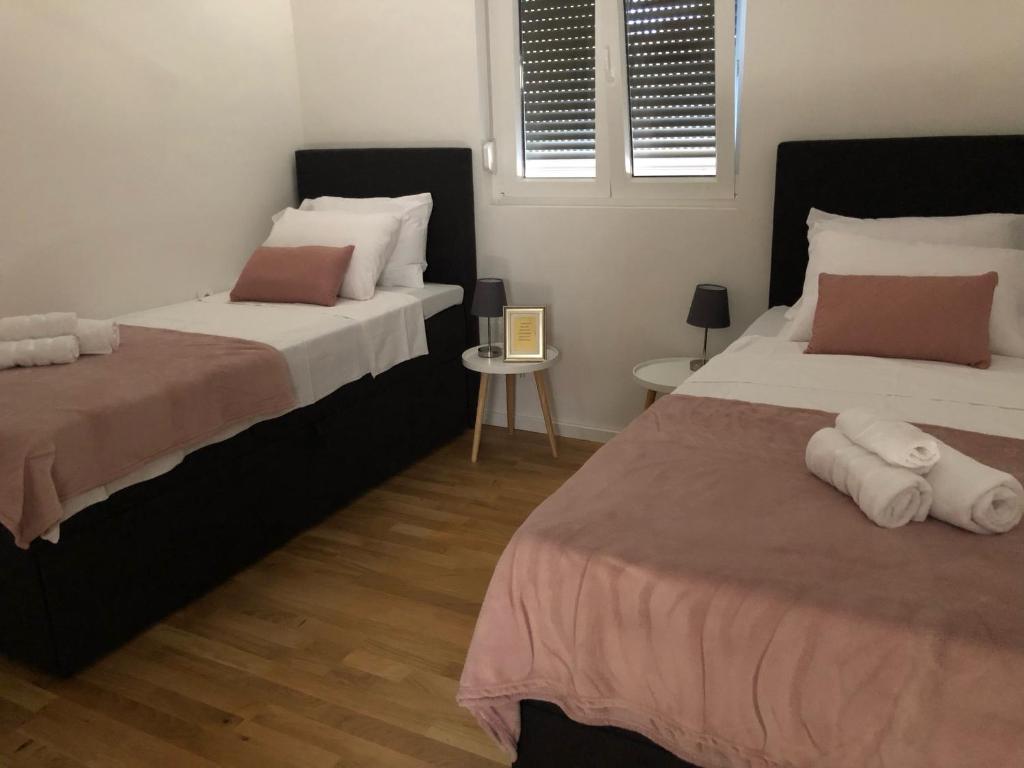 a bedroom with two beds and a table at Apartman FILIPA in Jezera