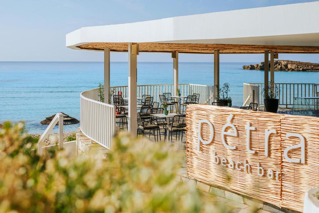 a restaurant with tables and chairs on the beach at Nissi Beach Resort in Ayia Napa