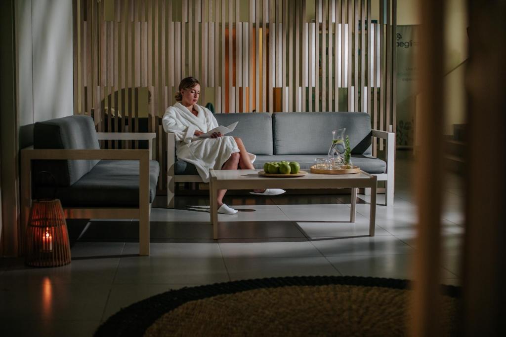a woman sitting on a couch in a living room at Nissi Beach Resort in Ayia Napa