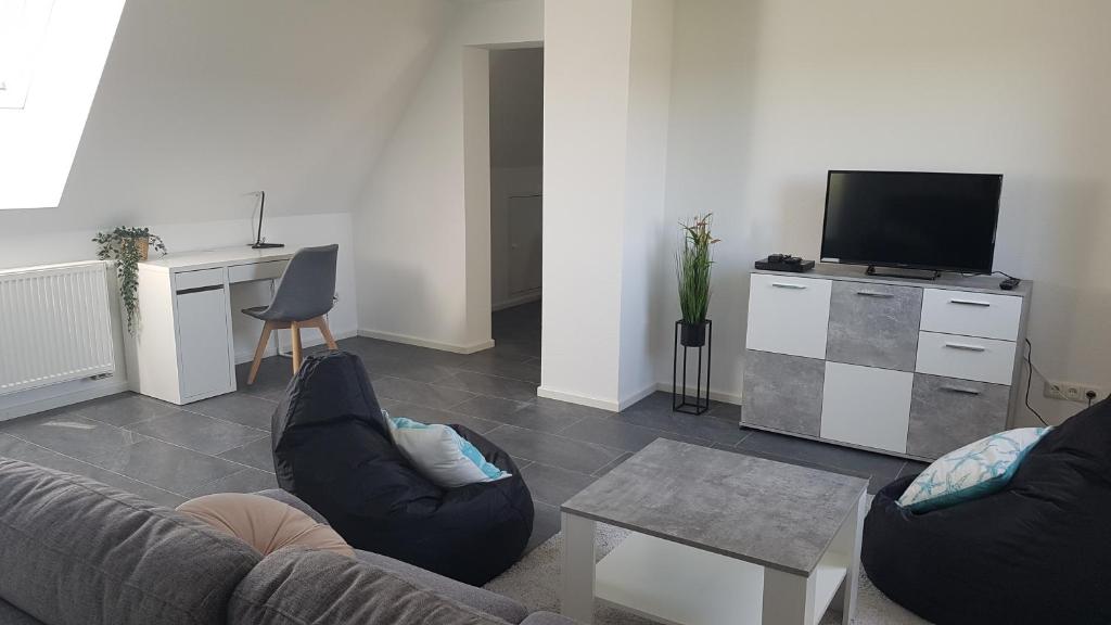 a living room with a couch and a tv at Ferienwohnung Höchberg in Höchberg