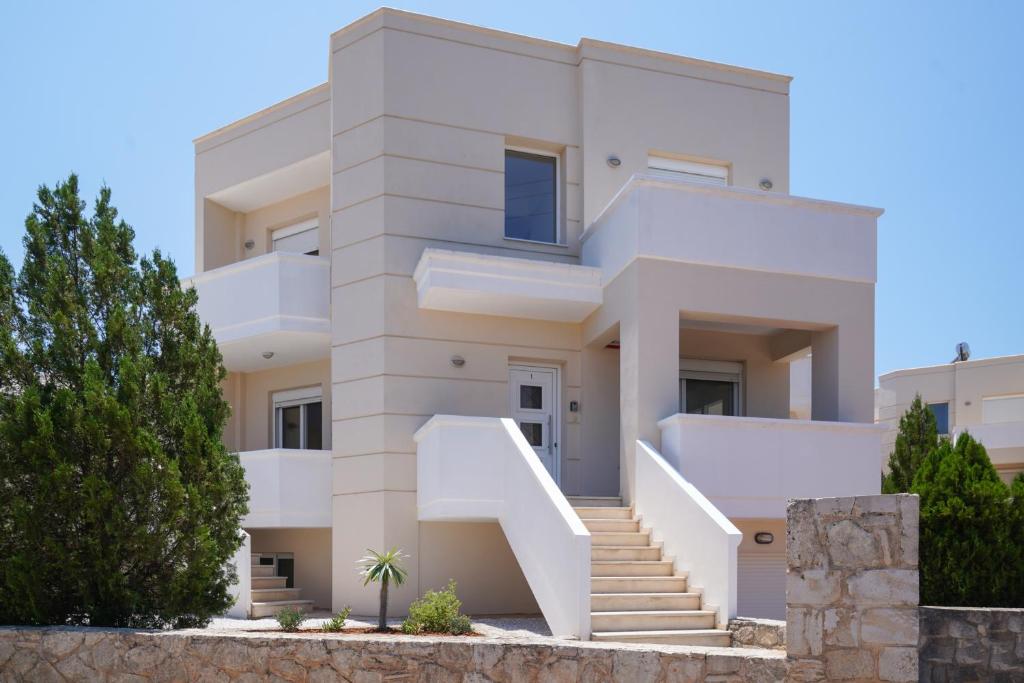 uma casa branca com escadas em frente em Hestia Maisonette em Arónion