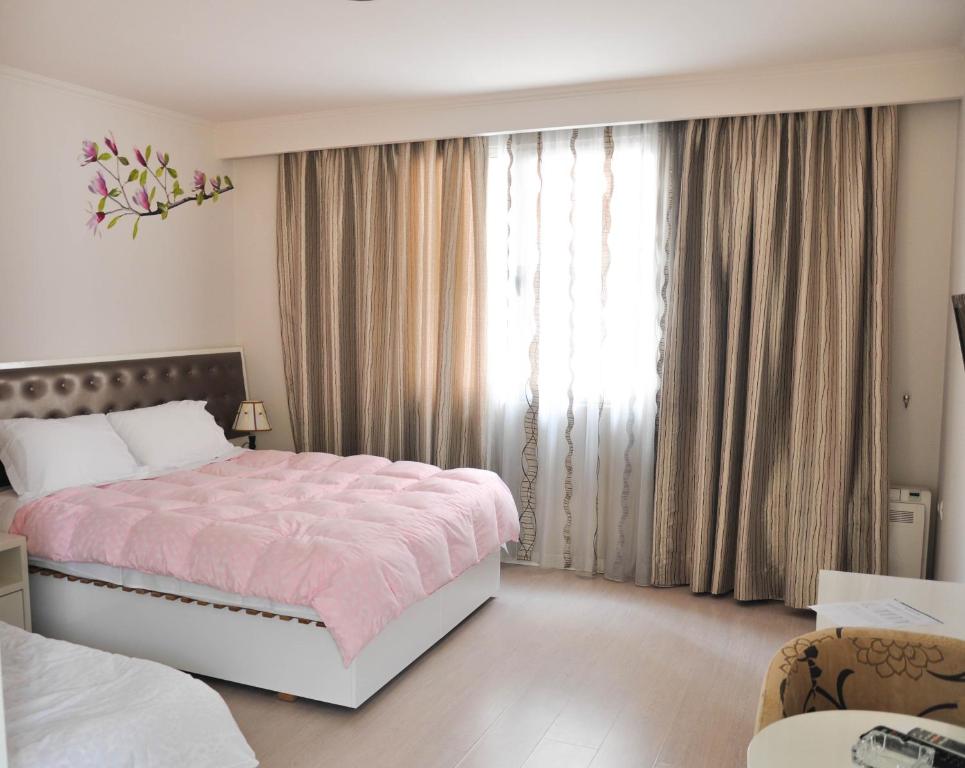 - une chambre avec un lit rose et une grande fenêtre dans l'établissement Select City Center Hotel, à Tirana