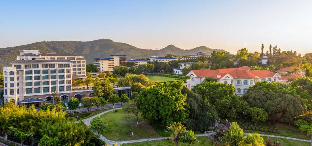 eine Stadt mit Gebäuden, Bäumen und Bergen im Hintergrund in der Unterkunft Xiamen C&D Hotel-Free Welcome Snacks-Oasis Garden in Xiamen