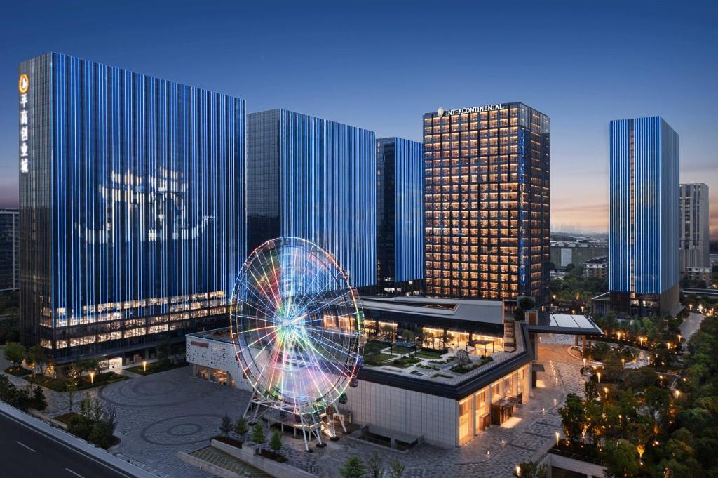 a city with a ferris wheel in front of tall buildings at InterContinental Hangzhou Liangzhu, an IHG Hotel in Hangzhou