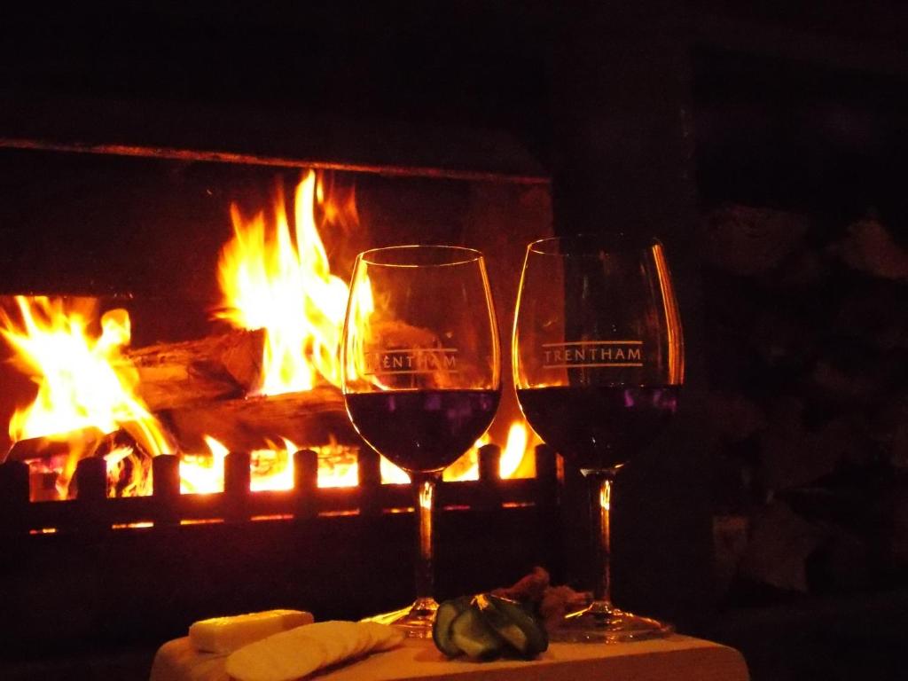 two glasses of wine sitting on a table in front of a fireplace at Port McCrae in McCrae