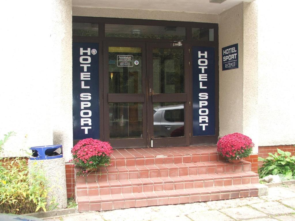 ヤブロネツ・ナド・ニソウにあるHotel Sportの階段の花の入った建物の玄関