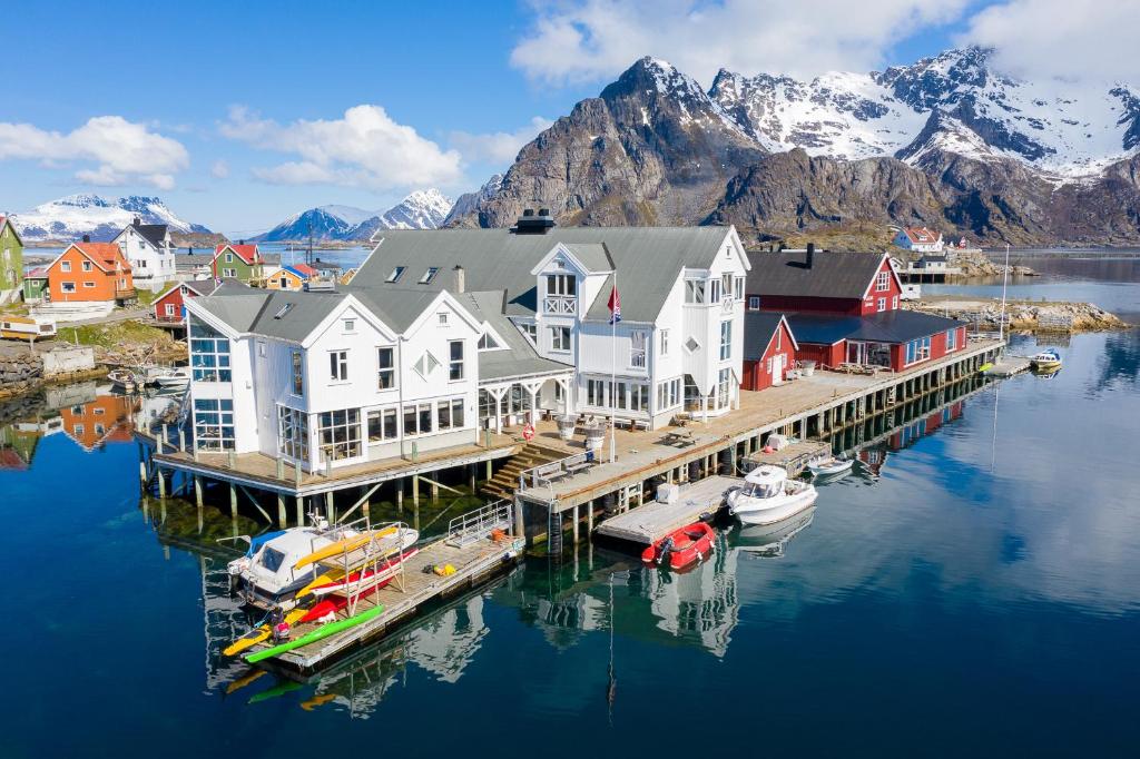 a group of houses on a dock in the water at Villa Bryggekanten - by Classic Norway Hotels in Henningsvær