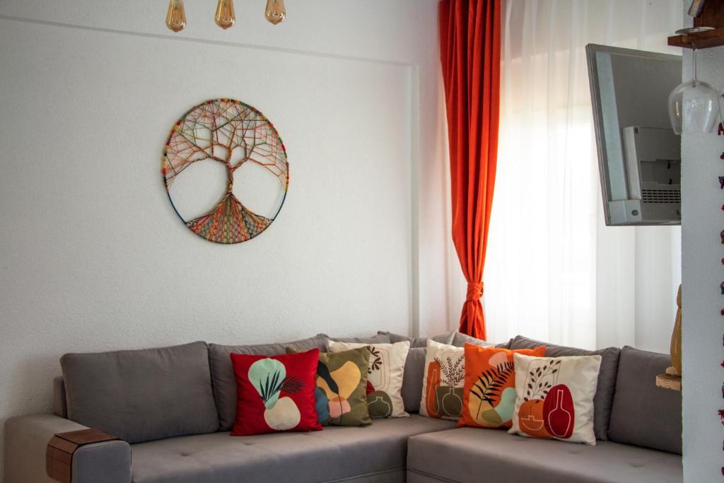 a living room with a gray couch with colorful pillows at Rentavill Villa Zeus in Bodrum City