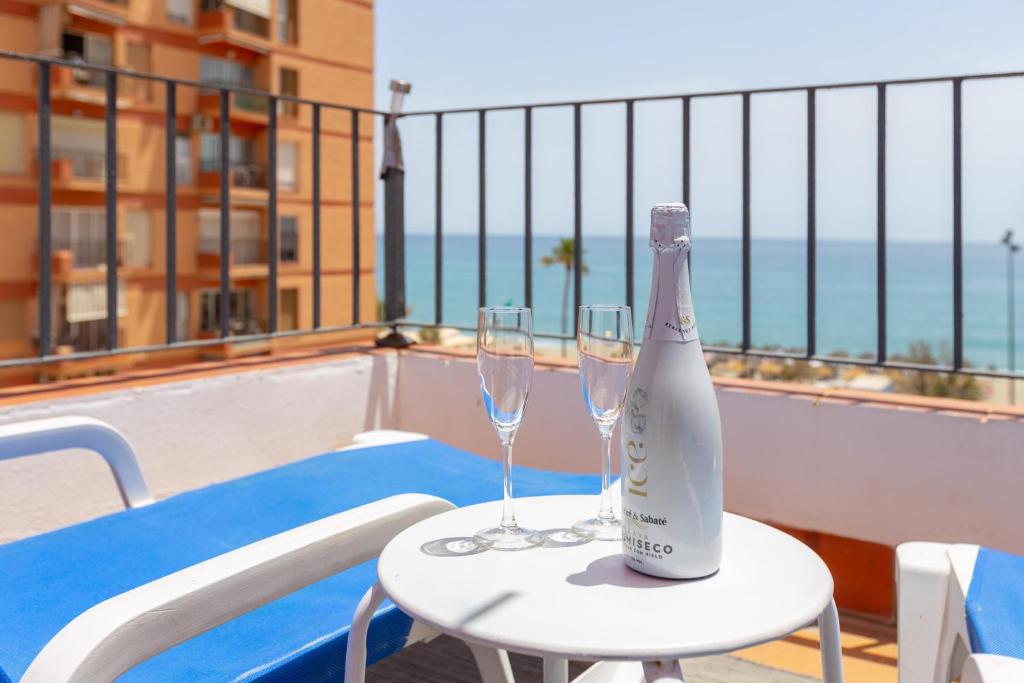 una bottiglia di champagne su un tavolo con due bicchieri di Marina Beach a Fuengirola