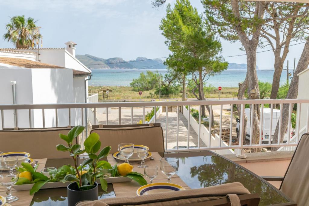 Una mesa en un balcón con vista al mar. en Sa Fornera, en Alcudia