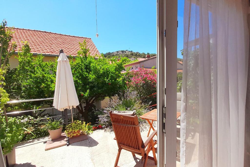 a patio with an umbrella and a table with a chair at Apartments Stella Mariela in Šibenik