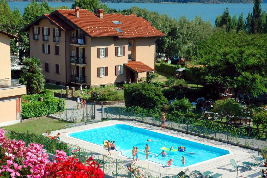 un gruppo di persone in una piscina accanto a un edificio di Residence Geranio a Domaso