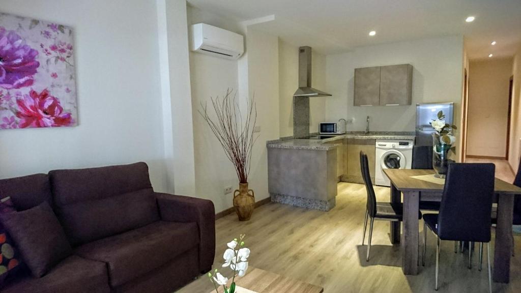 sala de estar con sofá, mesa y cocina en Apartamentos El Gallo, en Marbella