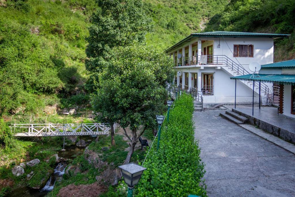a white house with a tree in front of it at Babutaal Resort in Chakrāta