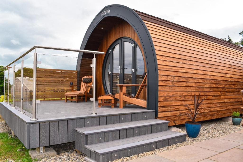 a house with a deck with a glass door at Derecroft Glamping Luxury Lodgepods in Lanchester