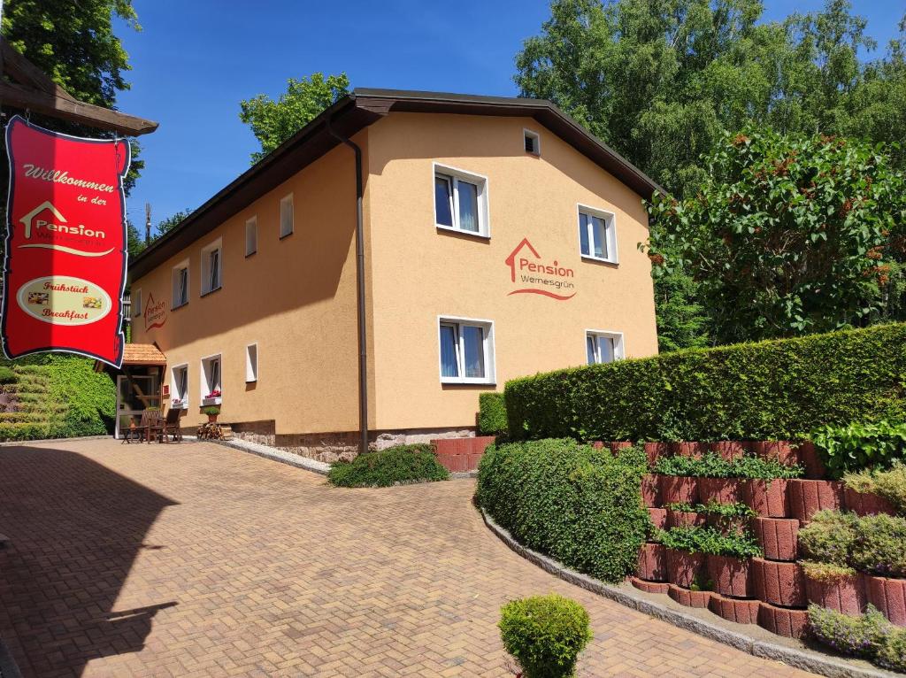 a large building with a brick walkway in front of it at Pension Wernesgrün in Wernesgrün