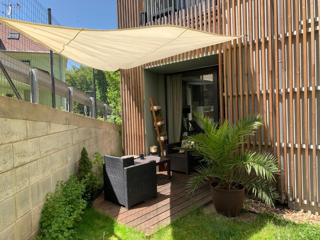 a patio with a tan umbrella on a building at Jezerní apartmán s terasou a saunou v Lakepark Residence in Doksy