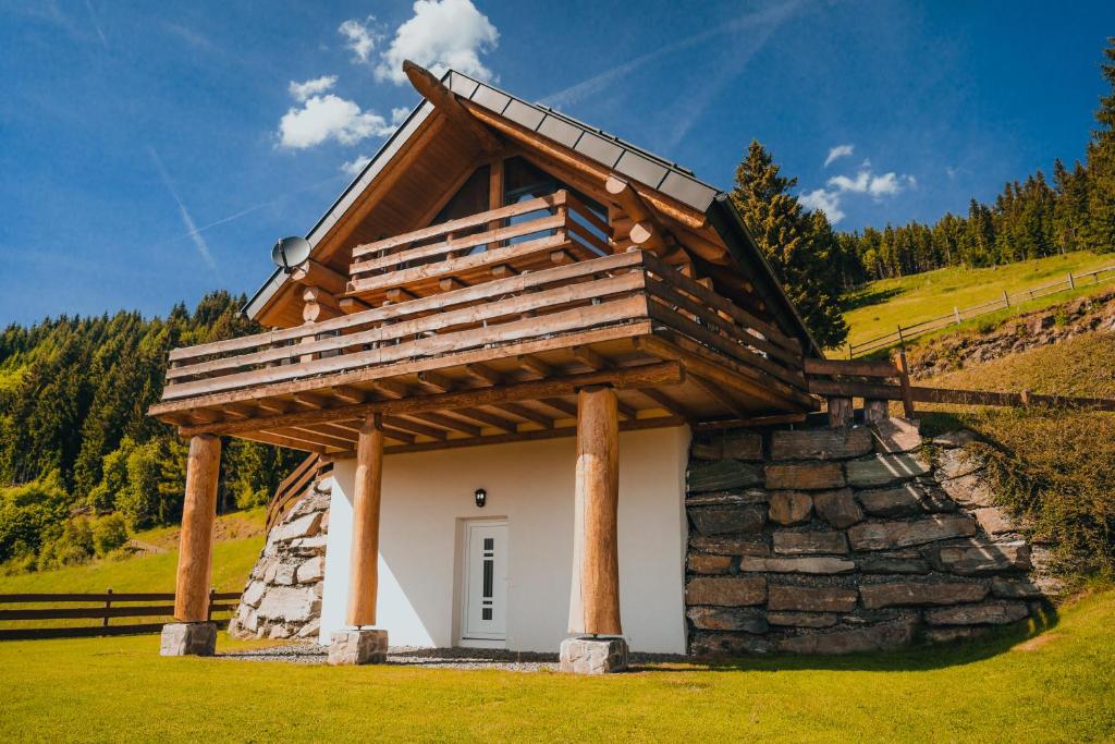 a house with a roof on top of a stone wall at Adlerkopfhütte in Zirkitz