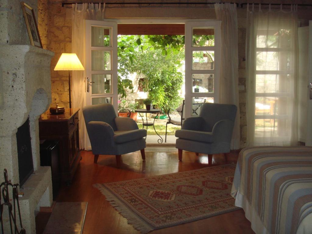 a bedroom with two chairs and a bed and a window at Incirliev - Special Category in Alaçatı