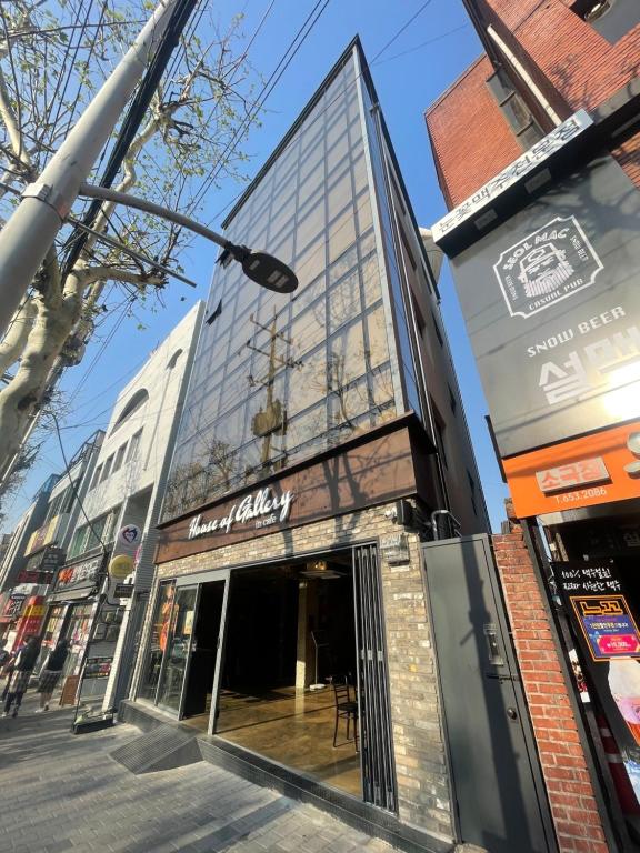 a building with a glass facade on a city street at House of gallery in Daegu