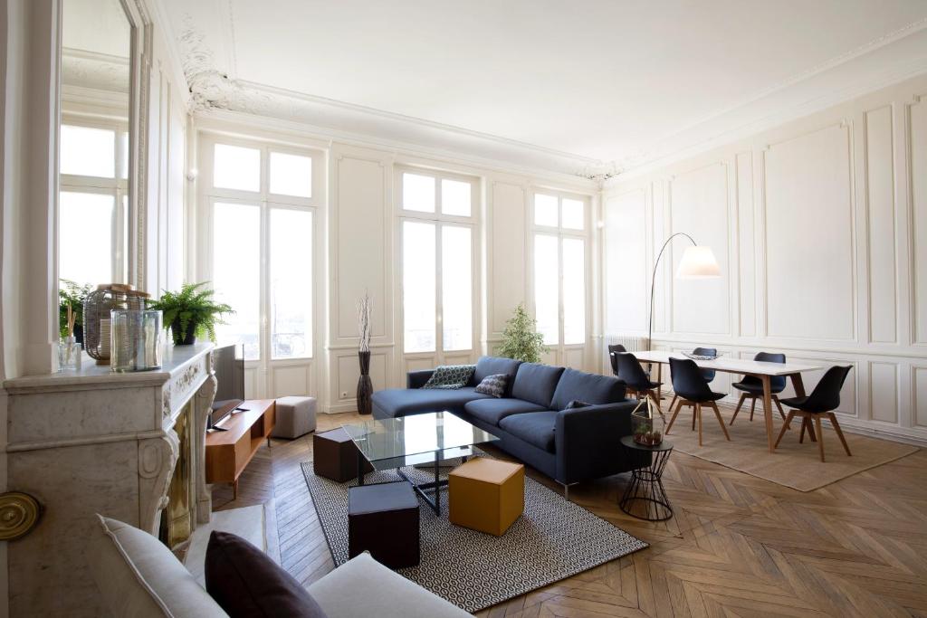 een woonkamer met een blauwe bank en een tafel bij Appartement sur les quais de Bordeaux in Bordeaux