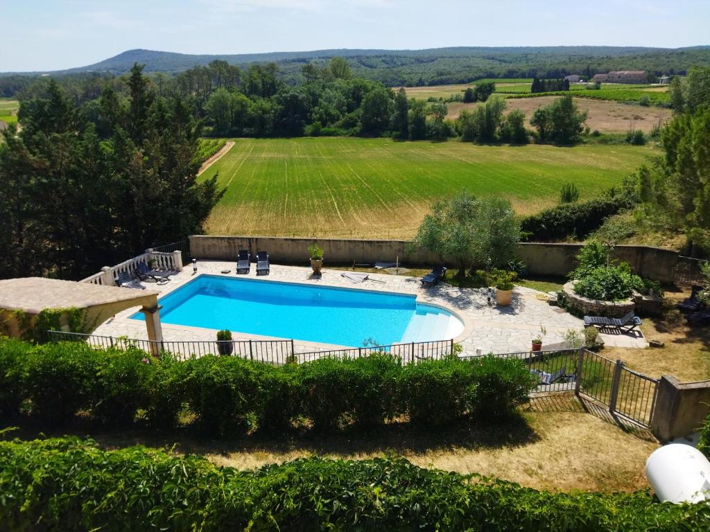 una vista aérea de una piscina en un patio con un campo en Mas de Lassagne en Vagnas