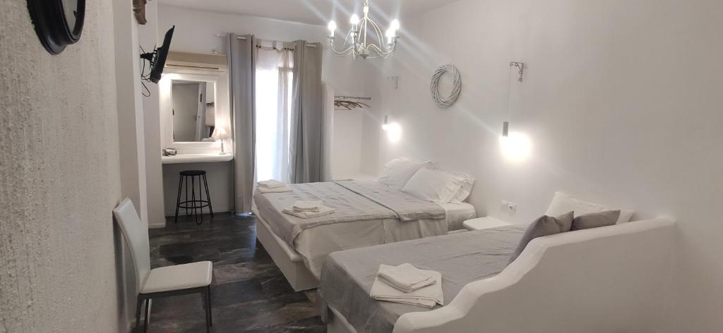 a white room with two beds and a mirror at Nora Norita in Batsi