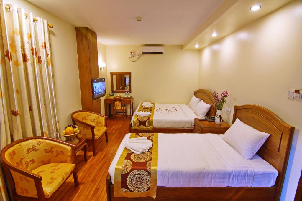 Habitación de hotel con 2 camas y sofá en Royal Pearl Hotel en Mandalay