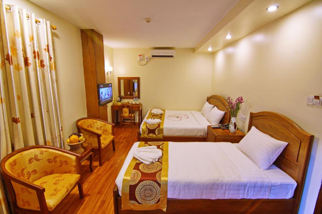 una camera d'albergo con due letti e un divano di Royal Pearl Hotel a Mandalay