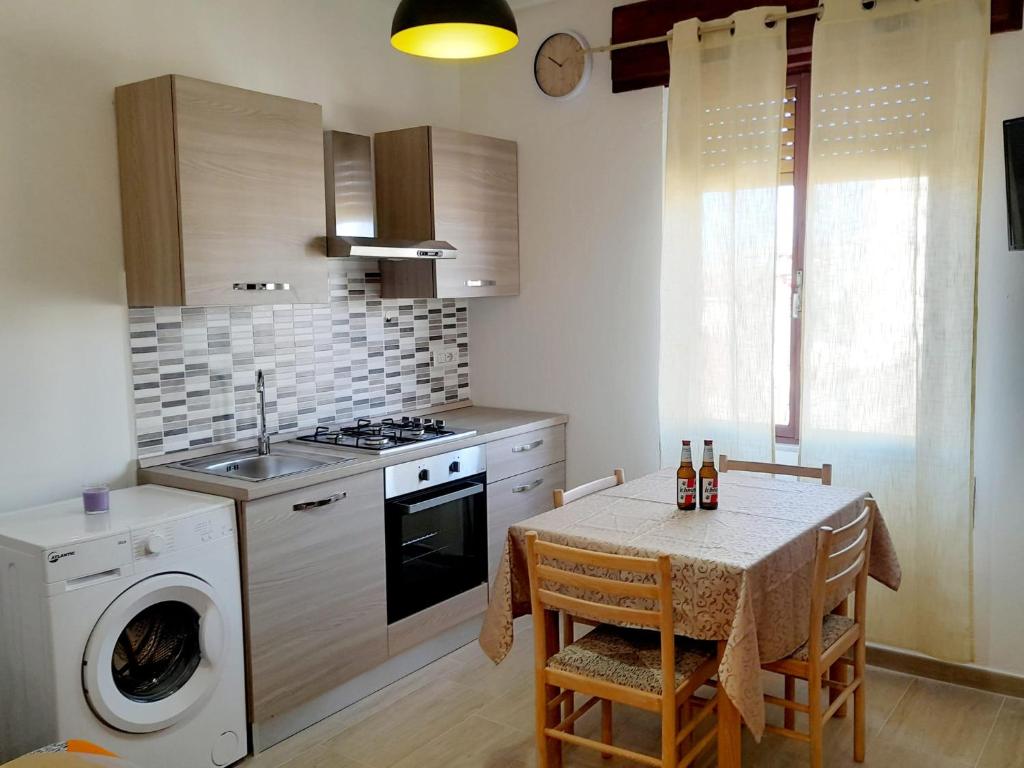a kitchen with a table and a washing machine at Grazioso bilocale in centro in Lotzorai