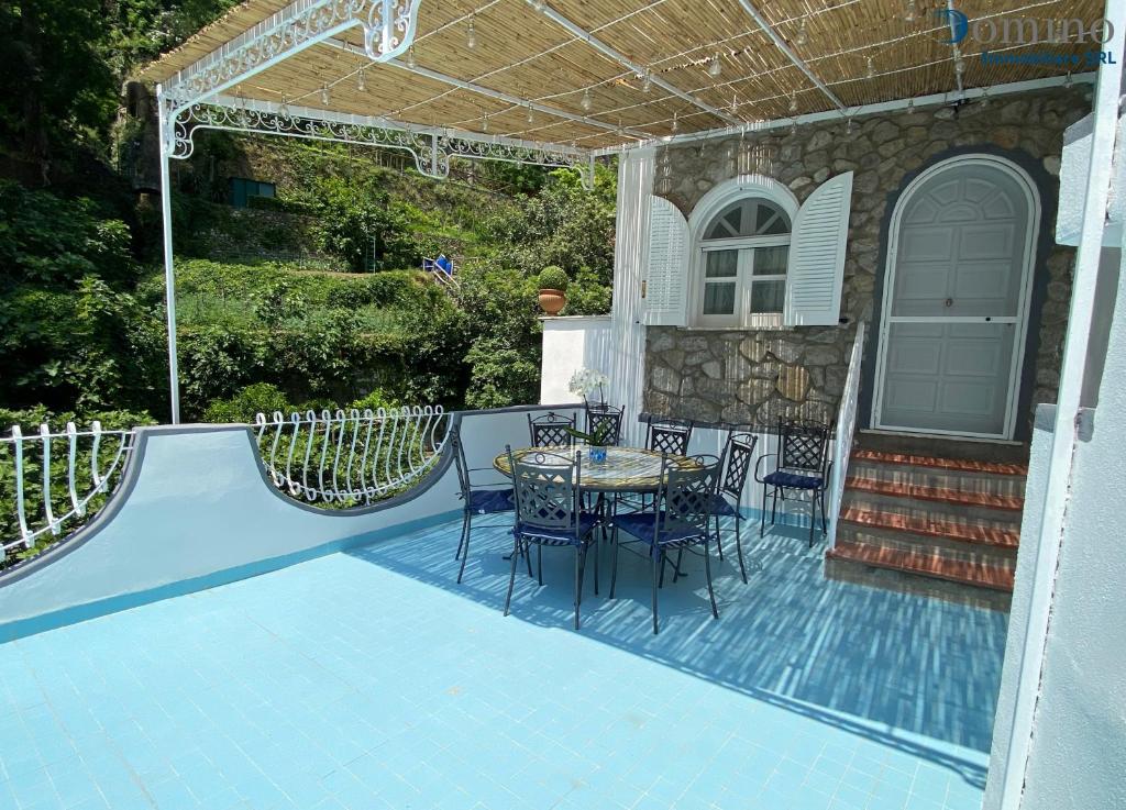 een patio met een tafel en stoelen naast een huis bij Casa L'Incanto in Positano