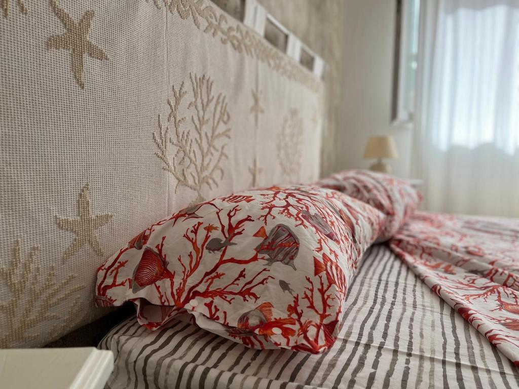a bed with a red and white pillow on it at Villa Vittoria in San Teodoro