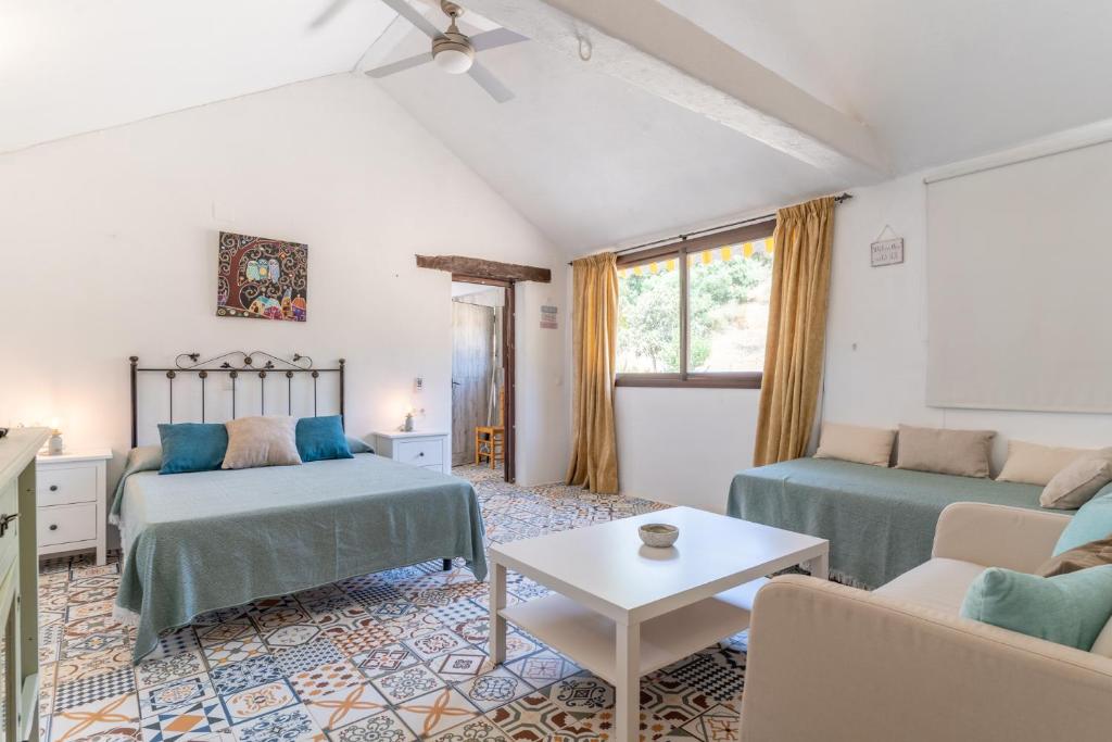 uma sala de estar com duas camas e um sofá em Finca Santa Teresa, Casa La Higuera em Casares