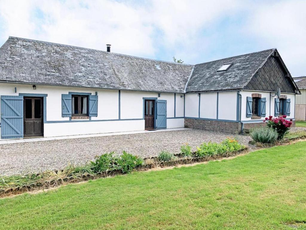 a white house with a gray roof and a yard at Le Camp Brousse 