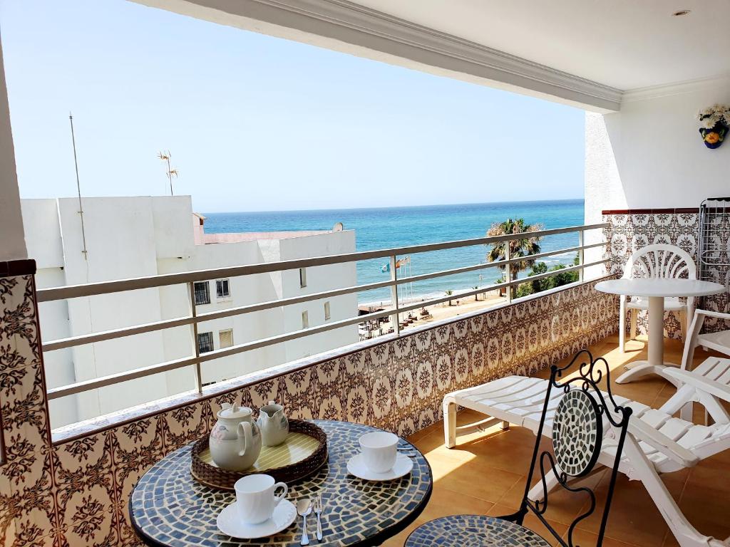 a room with a balcony with a view of the ocean at Luna Beach Seafront in Cabopino