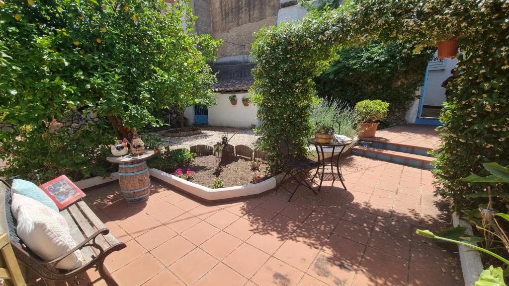 um pátio exterior com cadeiras, mesas e plantas em Giardino Dei Limoni Apartment em Oliena