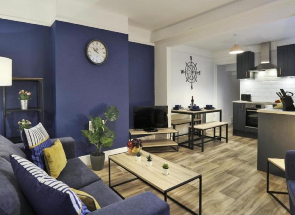 ein Wohnzimmer mit einem Sofa und einem Tisch in der Unterkunft Lake View Apartments, Oulton Broad in Lowestoft