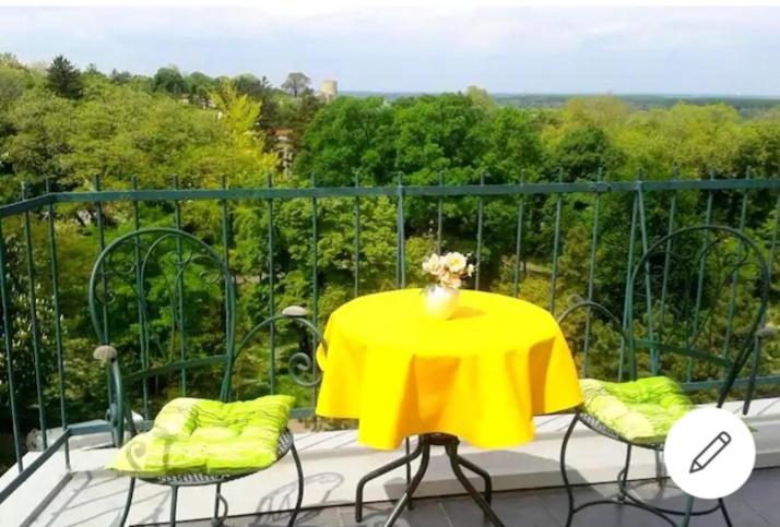 einen gelben Tisch und Stühle auf dem Balkon in der Unterkunft Apartment Bella Vista in Belgrad