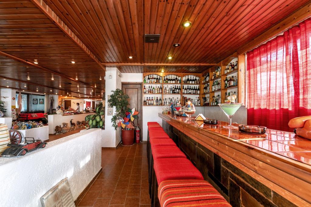a restaurant with a long bar with red seats at Hotel Tsagarakis Beach in Amoudara Herakliou