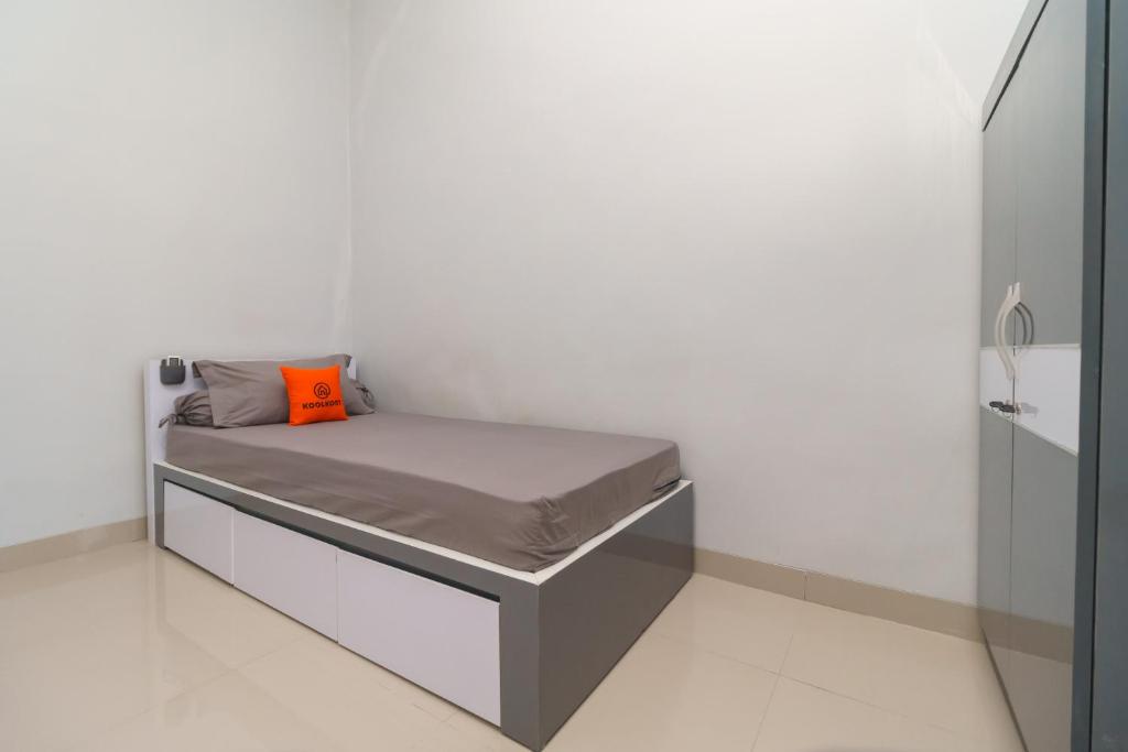 Kedaton的住宿－KoolKost Near Universitas Islam Negeri Raden Intan Lampung 2，小卧室配有带橙色枕头的床