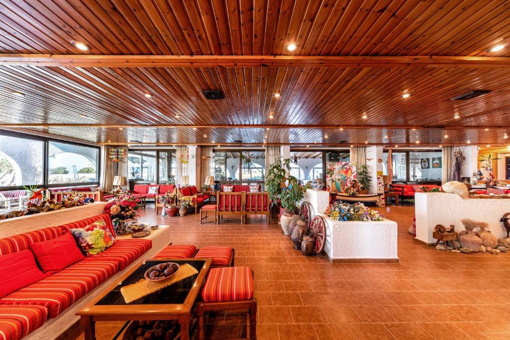 a large lobby with red couches and tables at Hotel Tsagarakis Beach in Amoudara Herakliou