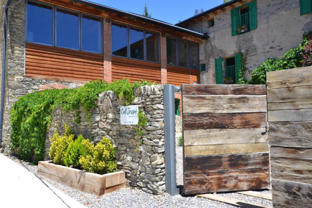 Casa con puerta de madera y pared de piedra en Apartament Cal Josepó, en Ger