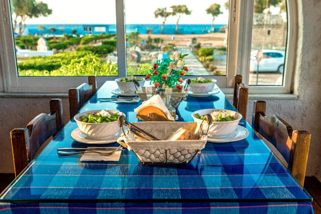 a table with a blue table cloth with a view of the ocean at Hotel Tsagarakis Beach in Amoudara Herakliou