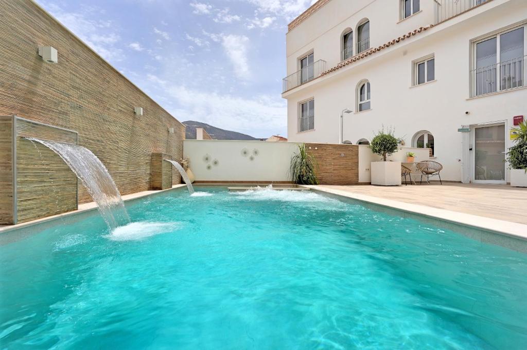 a swimming pool with a water fountain in front of a building at Alpujarra Secret in Órgiva