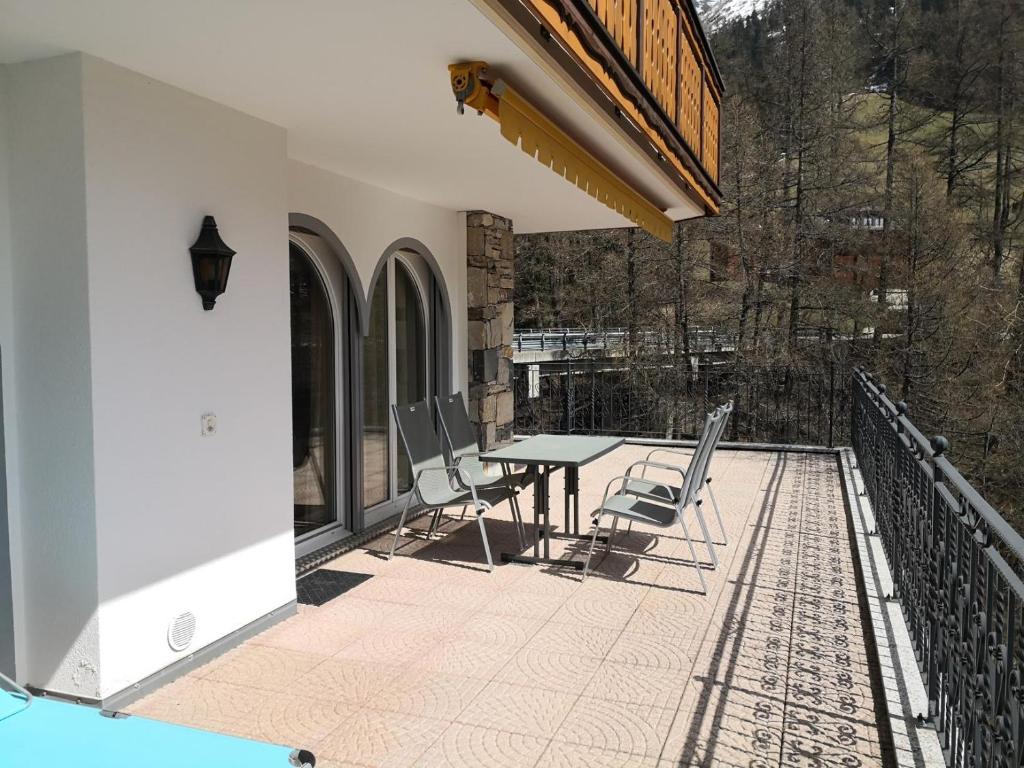 eine Terrasse mit einem Tisch und Stühlen auf dem Balkon in der Unterkunft Al Ponte 4 in Leukerbad