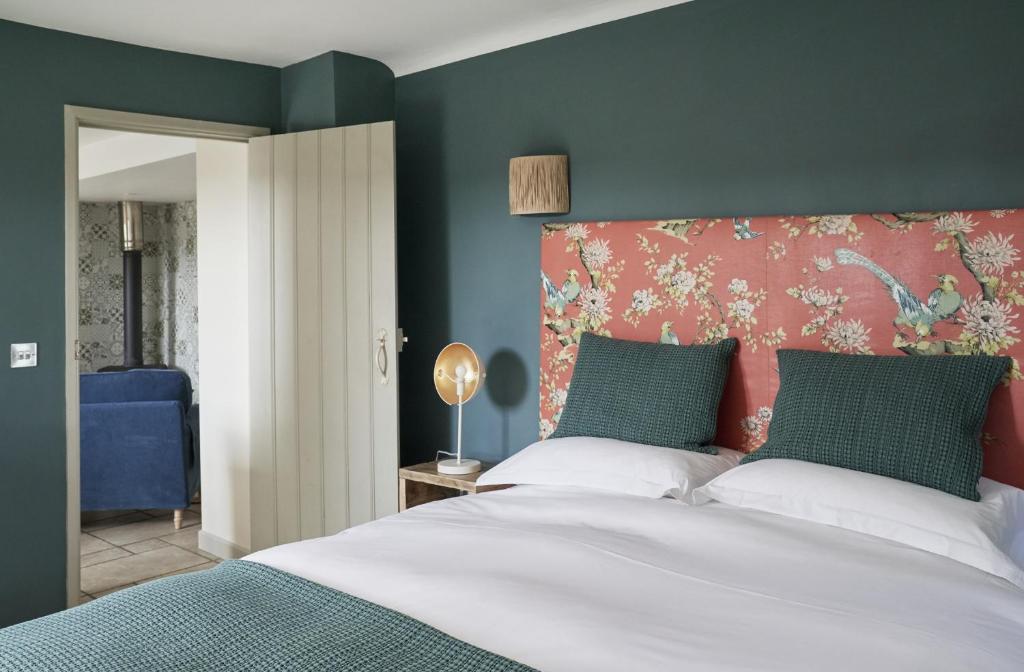 a bedroom with a large bed with a red headboard at The Cottages at Launceston Farm in Blandford Forum