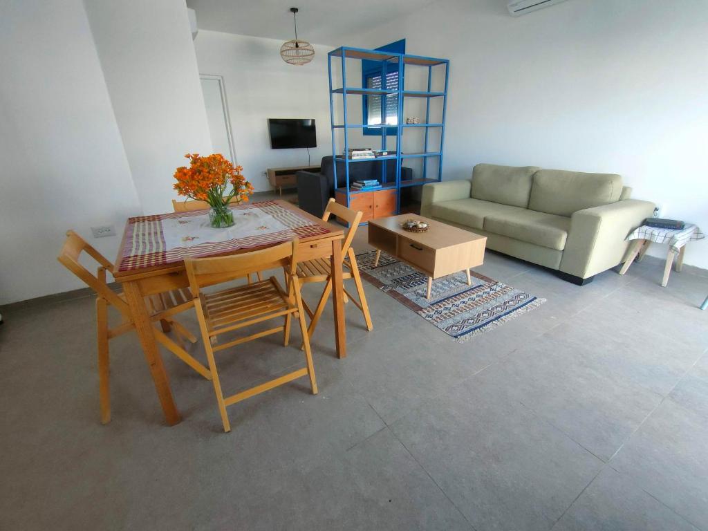 a living room with a table and chairs and a couch at Desert Path in Beʼer Ora