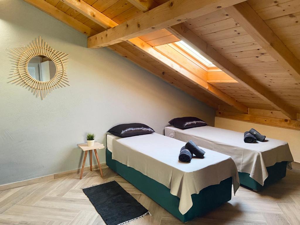 two beds in a attic room with a mirror at Apartment house GAIA in Gajac