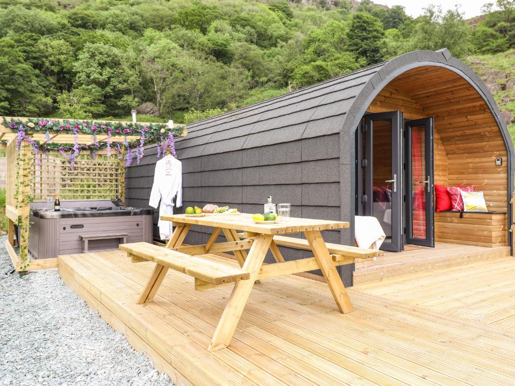 a wooden deck with a picnic table and a stove at Hartsop Magic - Crossgate Luxury Glamping in Penrith